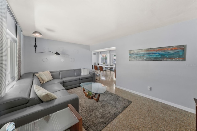 living area with speckled floor and baseboards
