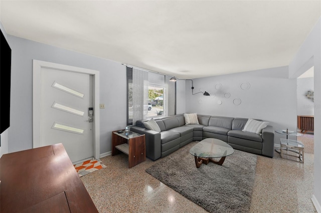 living room featuring speckled floor and baseboards