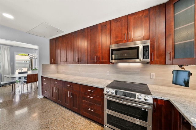 kitchen featuring tasteful backsplash, stainless steel appliances, glass insert cabinets, and reddish brown cabinets