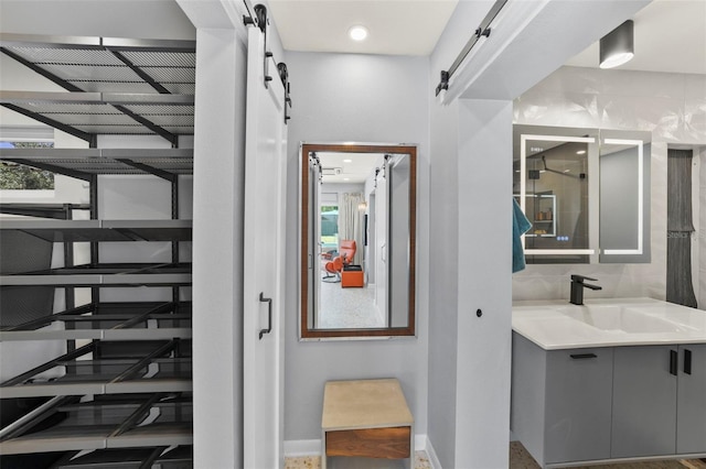 bathroom with baseboards, walk in shower, and vanity