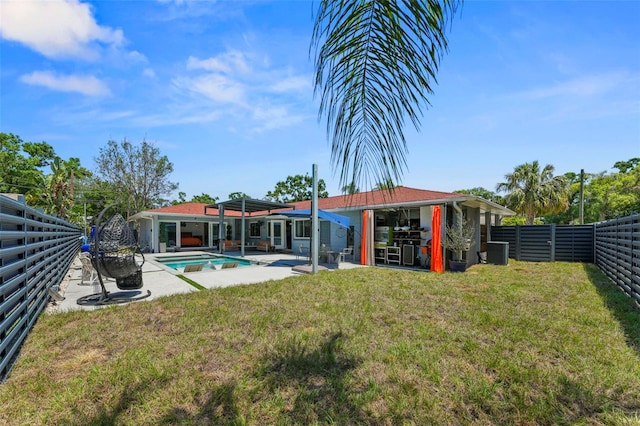 back of house featuring a fenced backyard, a yard, a fenced in pool, a patio, and central AC