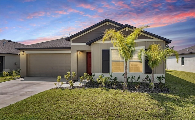 view of front of property featuring driveway, a yard, a garage, and stucco siding