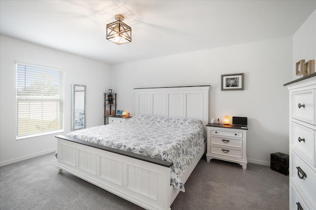 bedroom featuring dark carpet and baseboards