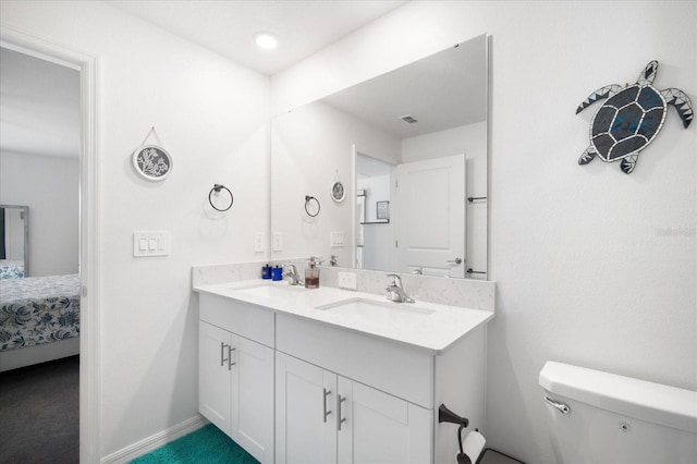 ensuite bathroom with connected bathroom, visible vents, toilet, and a sink