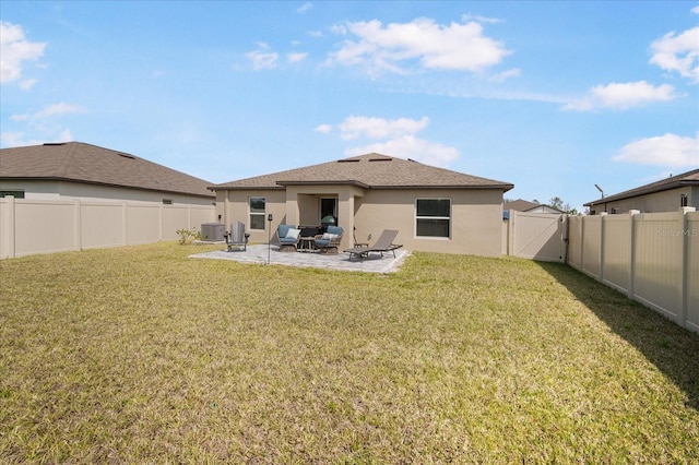 rear view of property with a gate, a patio area, stucco siding, central AC, and a fenced backyard