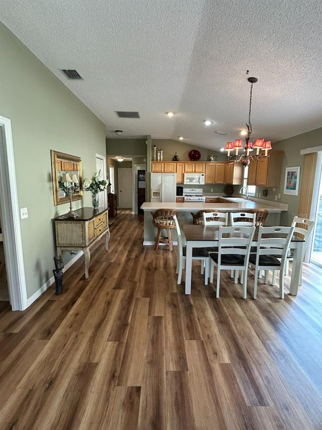 dining area featuring an inviting chandelier, dark wood-type flooring, visible vents, and a textured ceiling