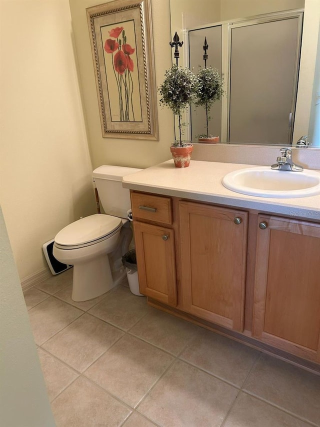 bathroom featuring toilet, a stall shower, tile patterned flooring, and vanity