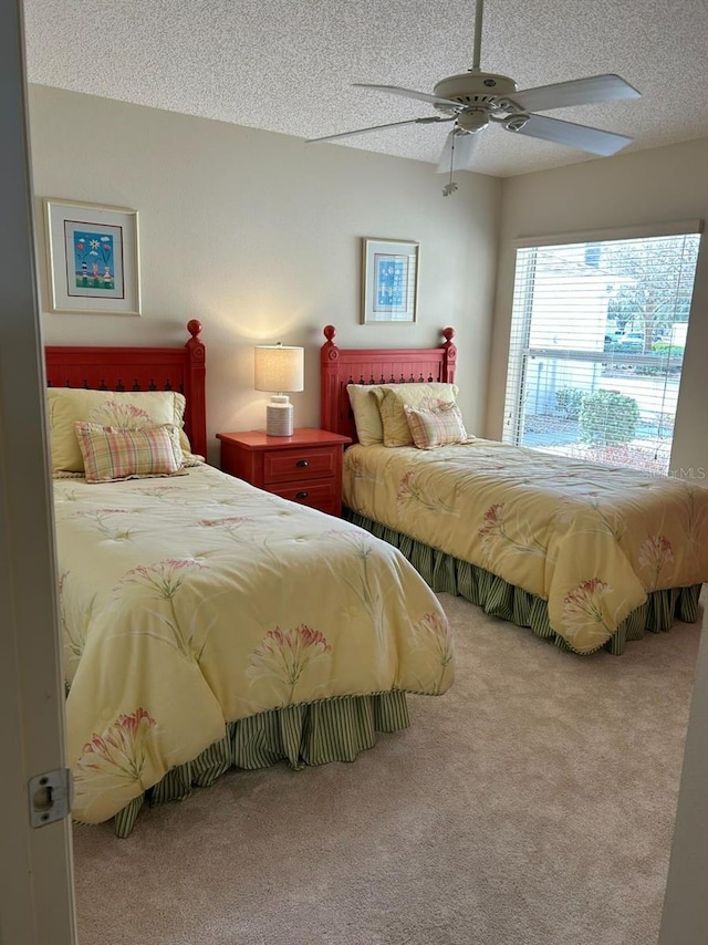 bedroom with a textured ceiling, a ceiling fan, and carpet