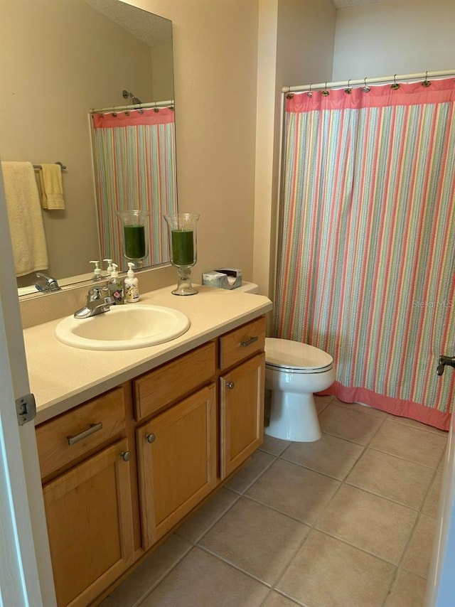 full bathroom featuring toilet, vanity, and tile patterned floors