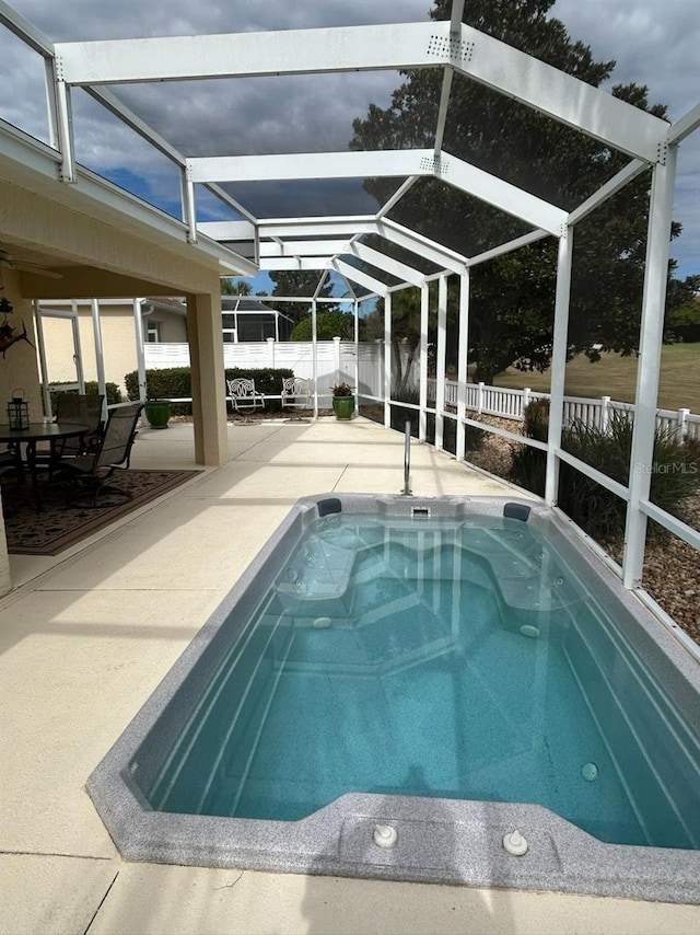 view of swimming pool featuring a patio, glass enclosure, and a fenced backyard