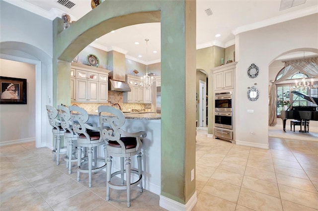 9630 Tree Tops Lake Rd, Tampa, FL 33626 - bar with tasteful backsplash, crown molding, extractor fan, arched walkways, and a notable chandelier