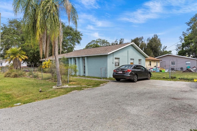 view of home's exterior with fence, driveway, a yard, and stucco siding