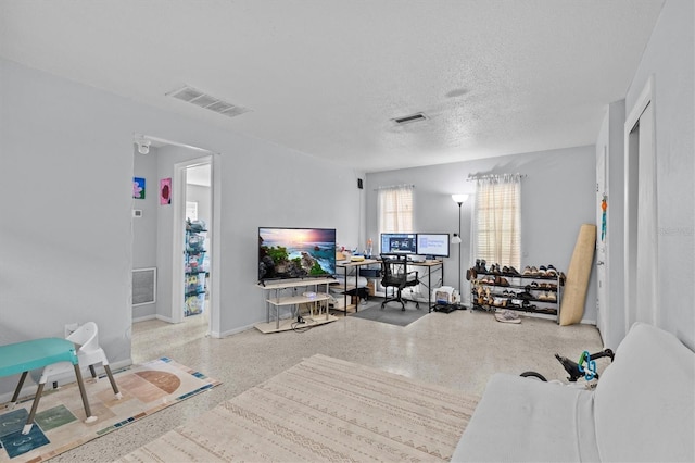 living room with speckled floor, baseboards, and visible vents