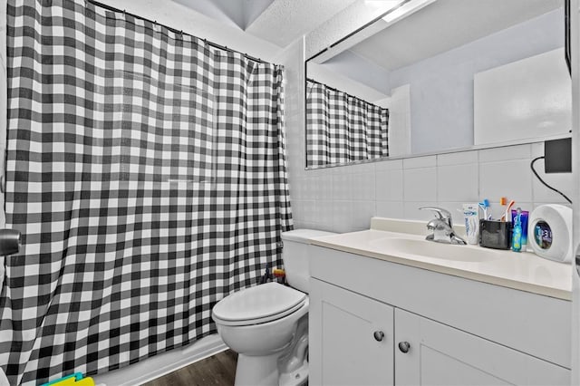full bath with wood finished floors, toilet, vanity, tile walls, and tasteful backsplash