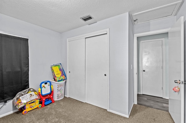rec room with a textured ceiling, carpet floors, visible vents, and baseboards