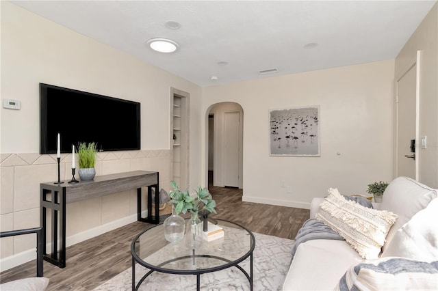 1419 55th St S, Gulfport, FL 33707 - living area featuring arched walkways, built in features, wood finished floors, and baseboards