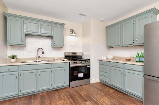 1419 55th St S, Gulfport, FL 33707 - kitchen with stainless steel appliances, a sink, light countertops, dark wood-style floors, and backsplash