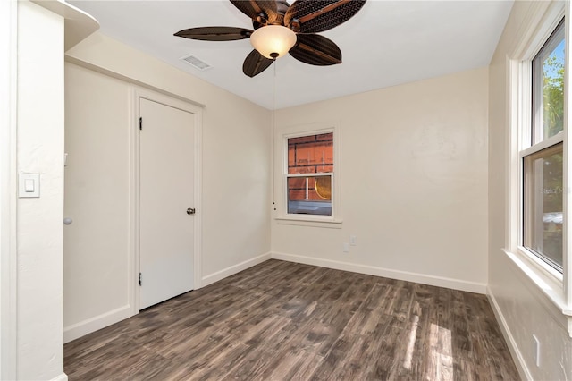 1419 55th St S, Gulfport, FL 33707 - unfurnished bedroom with dark wood-style flooring, baseboards, and a ceiling fan
