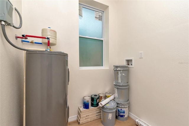 1419 55th St S, Gulfport, FL 33707 - laundry view of electric water heater, baseboards, and wood finished floors