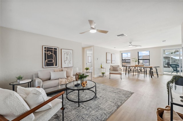 13810 Malcolm Ave, Hudson, FL 34667 - living room with a ceiling fan, light wood-style floors, and baseboards