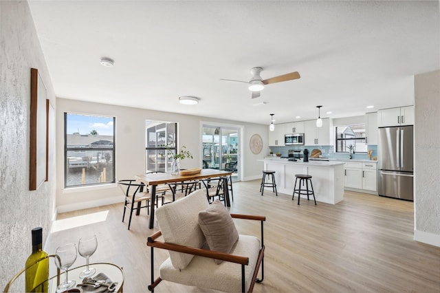 13810 Malcolm Ave, Hudson, FL 34667 - dining room featuring light wood-style flooring, ceiling fan, and baseboards