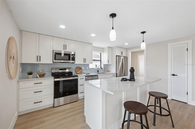13810 Malcolm Ave, Hudson, FL 34667 - kitchen with stainless steel appliances, a sink, light wood-type flooring, a kitchen breakfast bar, and recessed lighting