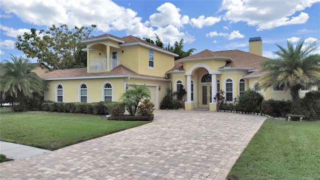 1312 Fishing Lake Dr, Odessa, FL 33556 - mediterranean / spanish-style home with stucco siding, decorative driveway, a balcony, and a front yard