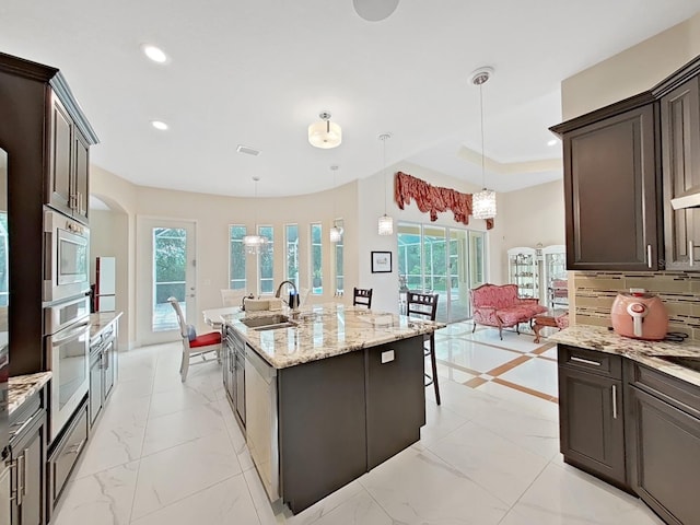 1312 Fishing Lake Dr, Odessa, FL 33556 - kitchen featuring a sink, recessed lighting, light stone countertops, an island with sink, and appliances with stainless steel finishes