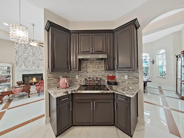 1312 Fishing Lake Dr, Odessa, FL 33556 - kitchen with decorative backsplash, under cabinet range hood, and light stone countertops
