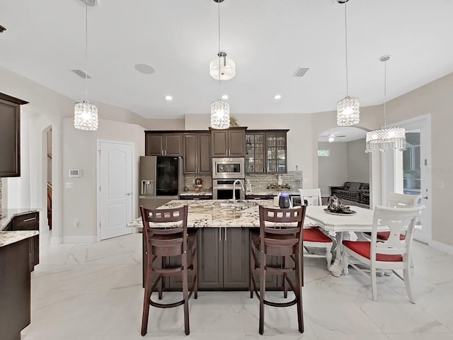1312 Fishing Lake Dr, Odessa, FL 33556 - kitchen featuring dark brown cabinetry, stainless steel appliances, marble finish floor, and arched walkways