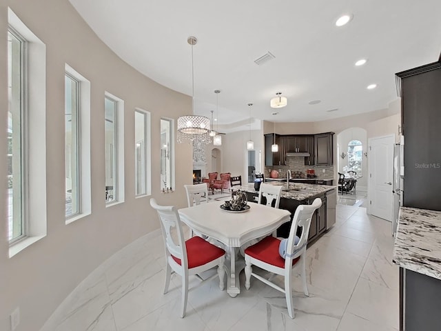 1312 Fishing Lake Dr, Odessa, FL 33556 - dining room featuring marble finish floor, arched walkways, baseboards, visible vents, and recessed lighting