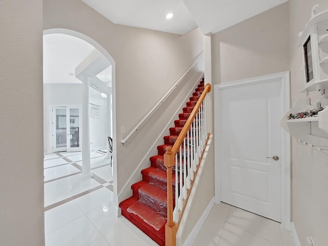 1312 Fishing Lake Dr, Odessa, FL 33556 - stairway with tile patterned floors, baseboards, and arched walkways