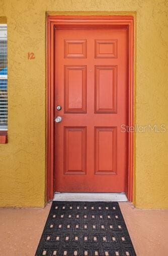 entrance to property with stucco siding