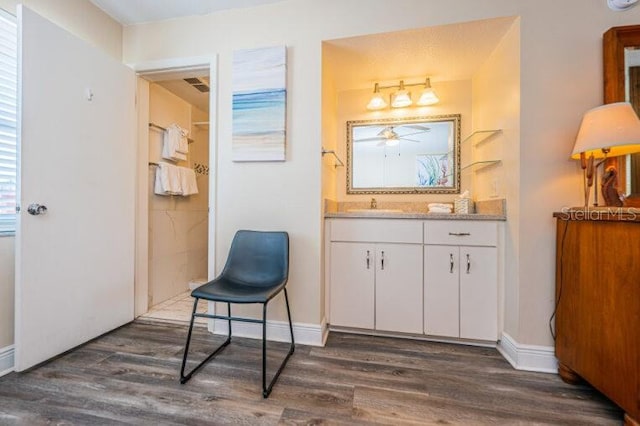 sitting room featuring visible vents, baseboards, ceiling fan, and dark wood-style floors