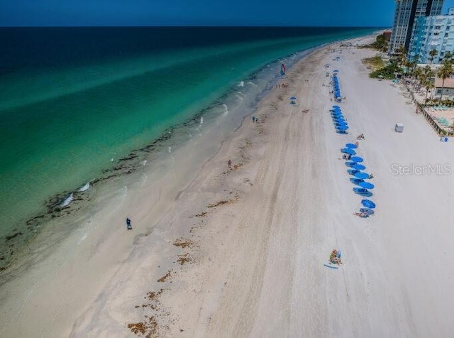 drone / aerial view featuring a water view and a view of the beach