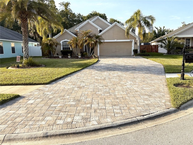 view of front of house with fence, a front lawn, driveway, and an attached garage