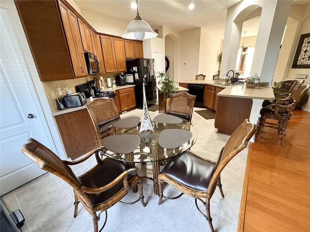 dining area with arched walkways and a textured ceiling
