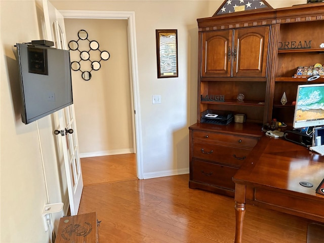home office featuring light wood finished floors and baseboards