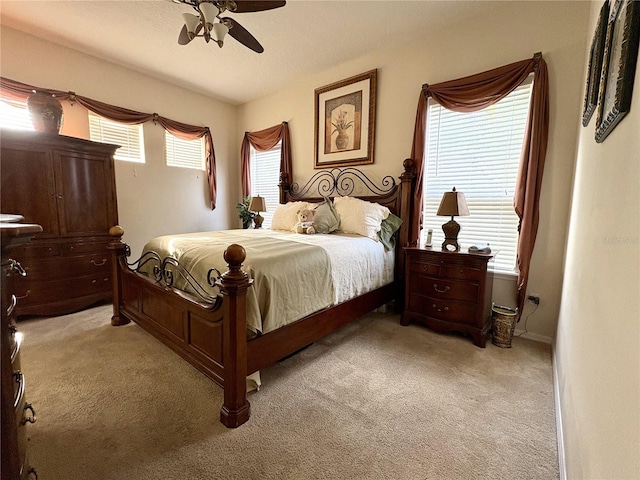bedroom with ceiling fan, light colored carpet, and baseboards