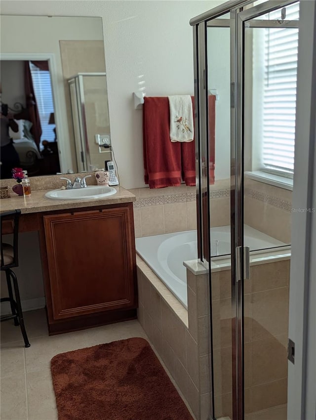 full bathroom with a stall shower, a garden tub, tile patterned flooring, and vanity