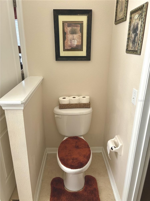 bathroom featuring tile patterned floors, baseboards, and toilet