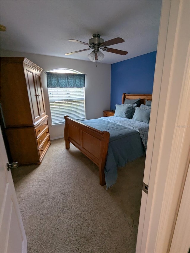 bedroom with a ceiling fan and light carpet