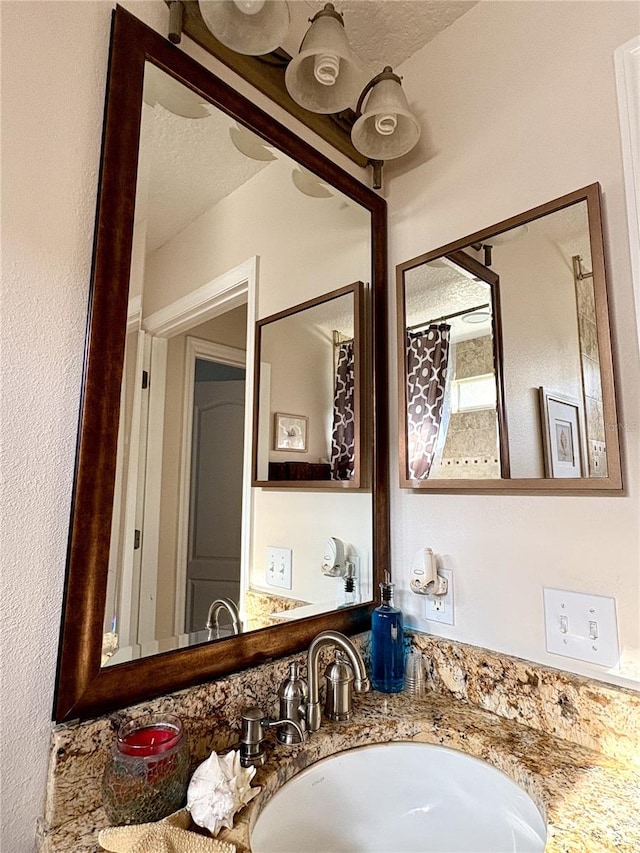bathroom with a textured ceiling and vanity