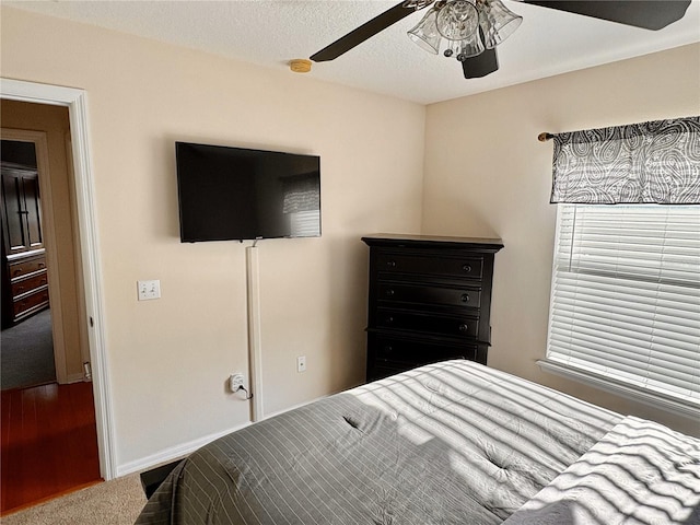 bedroom with baseboards, wood finished floors, and a ceiling fan