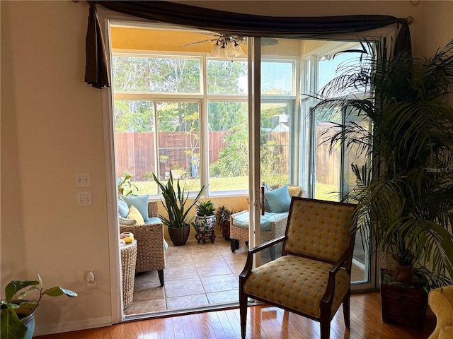 sunroom with wood-type flooring and a healthy amount of sunlight