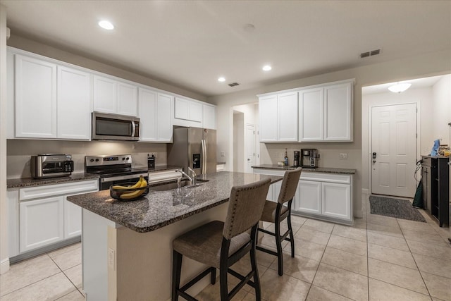 6225 Scarlet Darter Way, Tampa, FL 33625 - kitchen featuring stainless steel appliances, a sink, a kitchen bar, light tile patterned floors, and recessed lighting