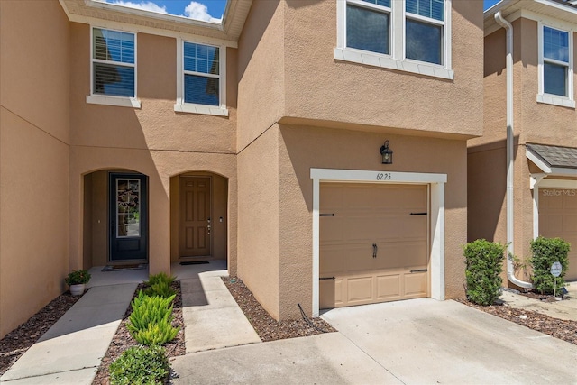 6225 Scarlet Darter Way, Tampa, FL 33625 - doorway to property featuring an attached garage, stucco siding, and concrete driveway