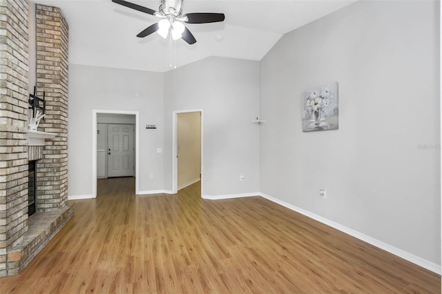 unfurnished living room featuring baseboards, high vaulted ceiling, a ceiling fan, wood finished floors, and a fireplace