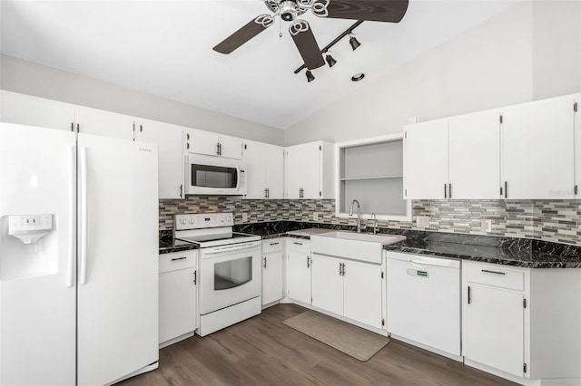kitchen featuring vaulted ceiling, tasteful backsplash, a sink, white appliances, and ceiling fan