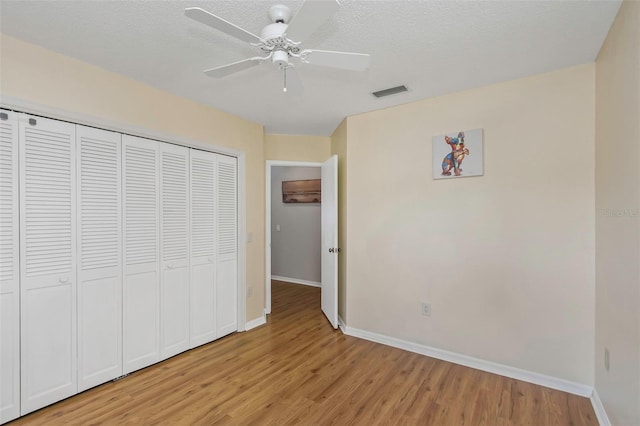 unfurnished bedroom featuring a closet, light wood-style floors, visible vents, and baseboards